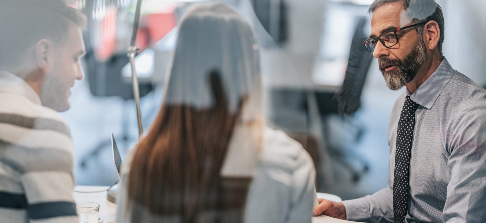 Une femme et deux hommes en réunion