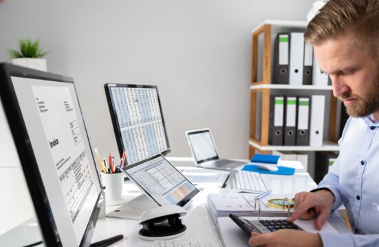Un professionnel analyse une facture électronique et des données comptables sur plusieurs écrans, illustrant le routage des factures.