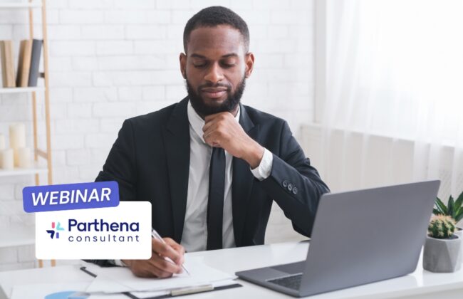 Homme en costume travaillant sur ordinateur lors d’un webinar.