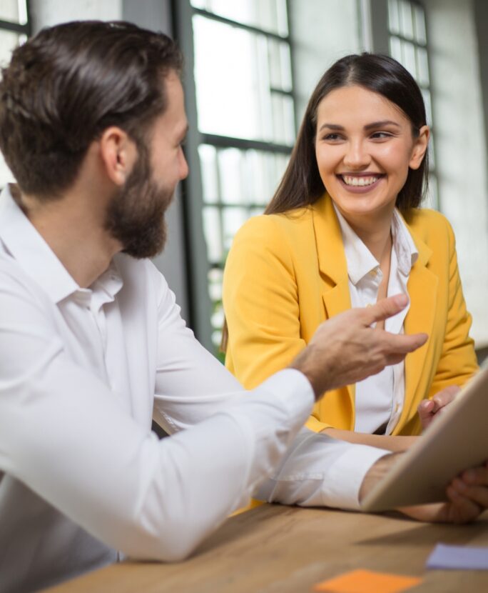 Un homme et une femme assit qui discute et parle projet