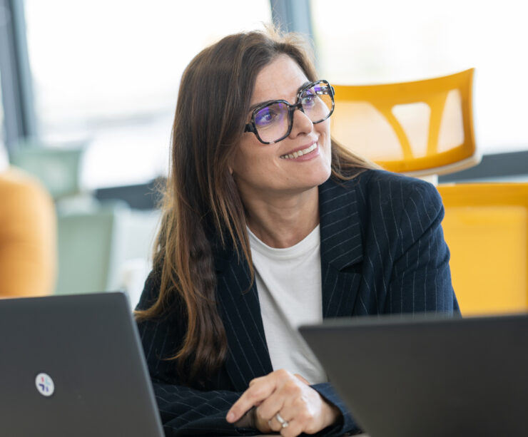 collaboratrice souriante sur ordinateur